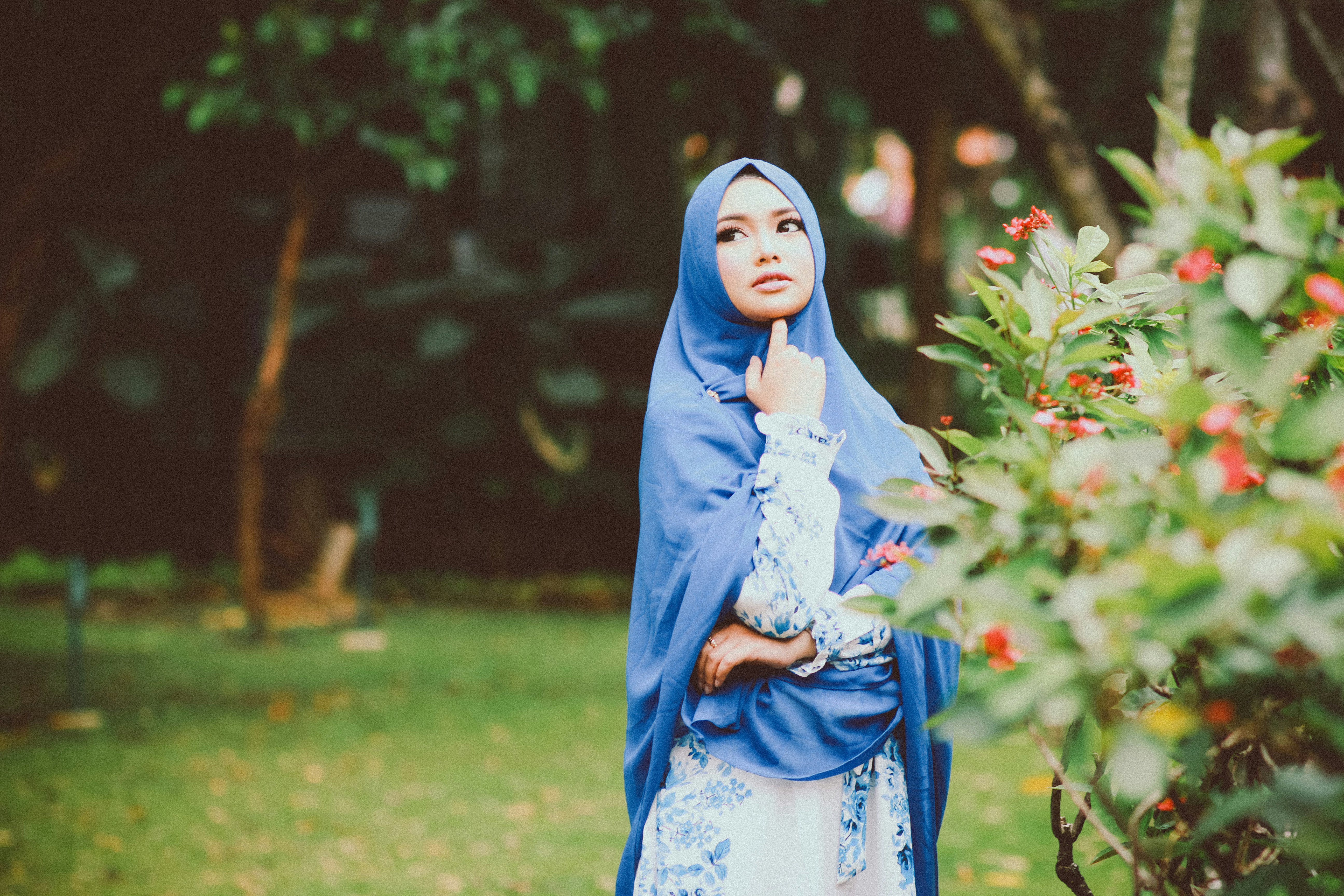 woman wearing blue and white long-sleeved dress beside green leaf plant